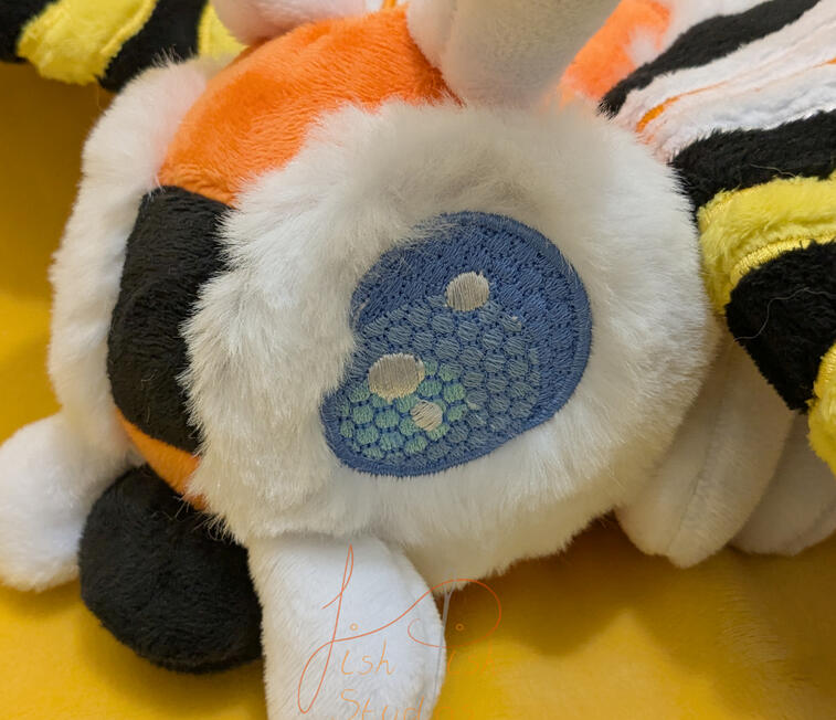 Mothra Plushie Close Up a handmade, highly detailed mothra plushie. This design comprises of applique, hand sewn parts, various fabrics and a very cute face. Made by fishpish studios in the UK