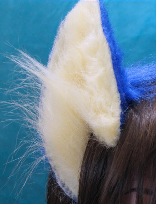 A close up of a pair of blue and cream flexible ears on a headband. the fabric is faux fur, these are made in the style of sonic