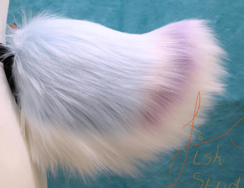 A custom missioned custom nub tail with a coloured tip. made of faux fur, it is designed for fursuit and cosplay use. made by fishpish studios