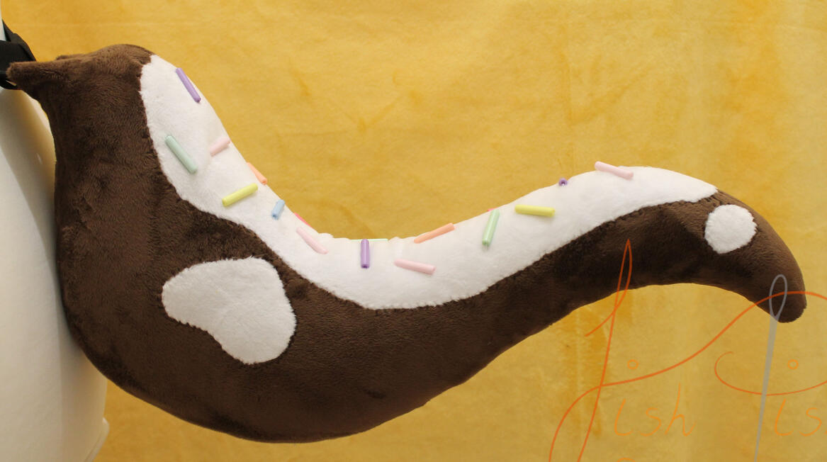 A one of a kind, cake tail with sprinkles. now sold, this item is made of soft plush/minky fabric and plastic bead like sprinkles. It sits about 21 inches long and is asymetrical. handmade and designed by fishpish studios