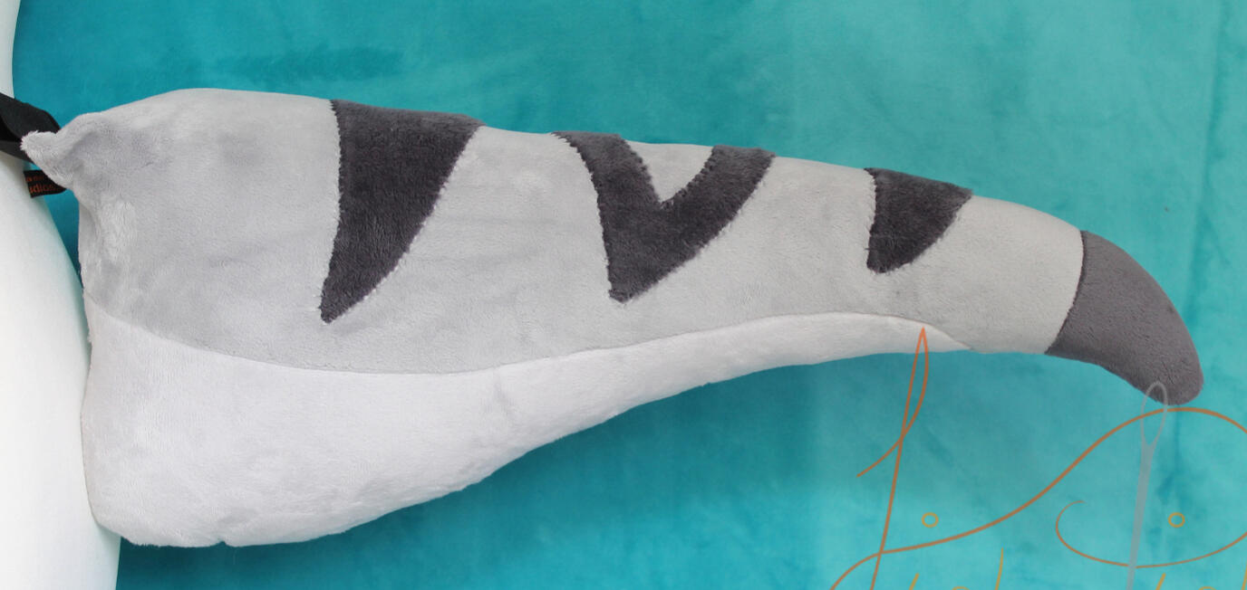 A commissioned piece, this is a raptor tail with customised stripes and a coloured tip. Made with various greys and white minky, it sits about 21 inches long, attaches via belt loops and is very plush and soft. designed by the commissioner and made by fish